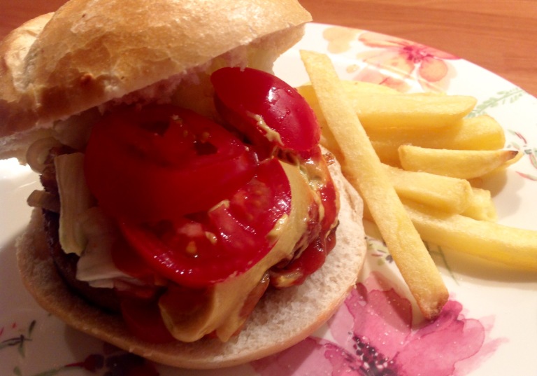 Vegan burger in a bun with potato fries