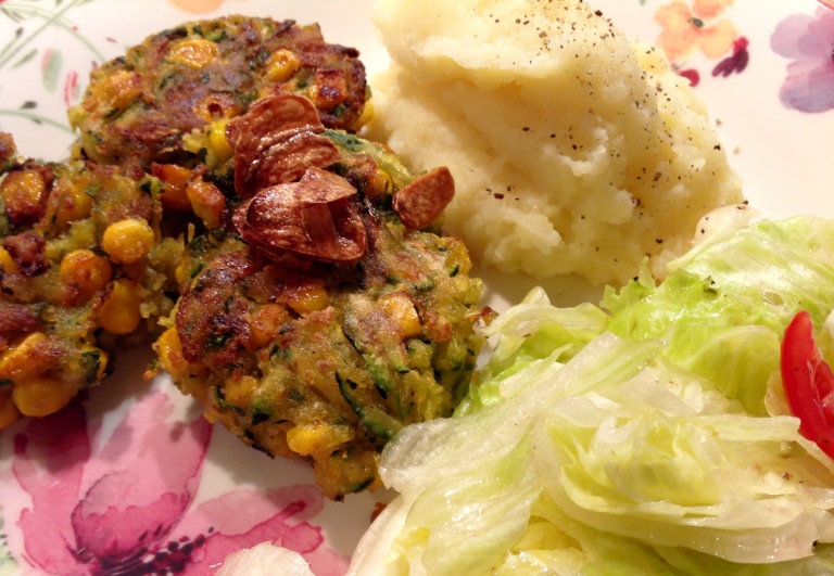 Zucchini and corn fritters with mashed potato and salad
